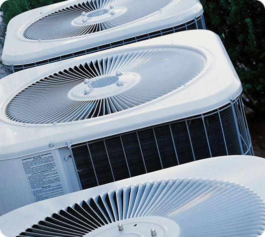 A row of air conditioners sitting on top of each other.