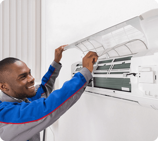 A man is fixing the air conditioner on his wall.