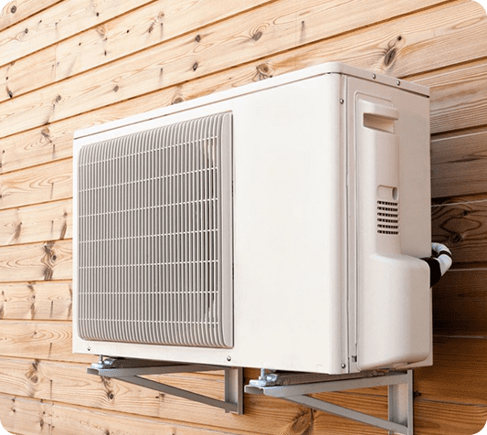 A white air conditioner mounted on the side of a building.