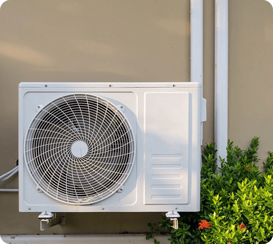 A white air conditioner sitting outside of a building.