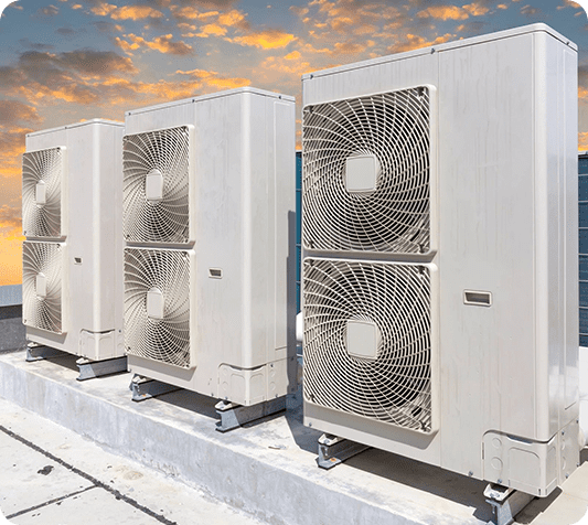 A row of air conditioners sitting on top of concrete.