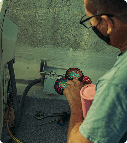 A man holding a wrench and adjusting the air compressor.