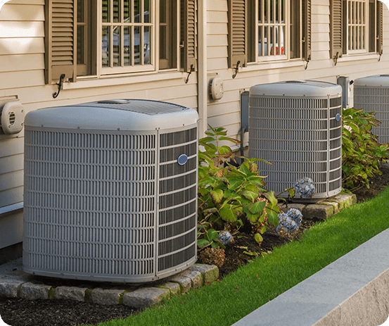 A couple of air conditioners sitting outside of a house.