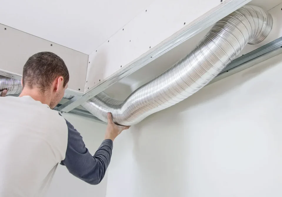 A man is working on the ceiling of his home.